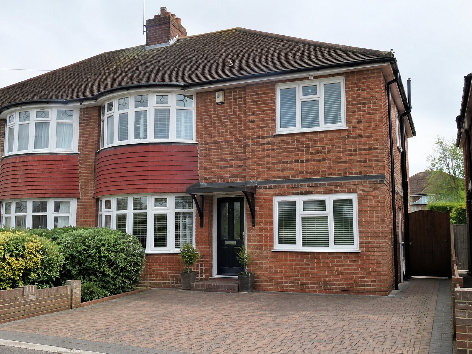 Illustrative image: brick semi-detached house with a converted garage and new window