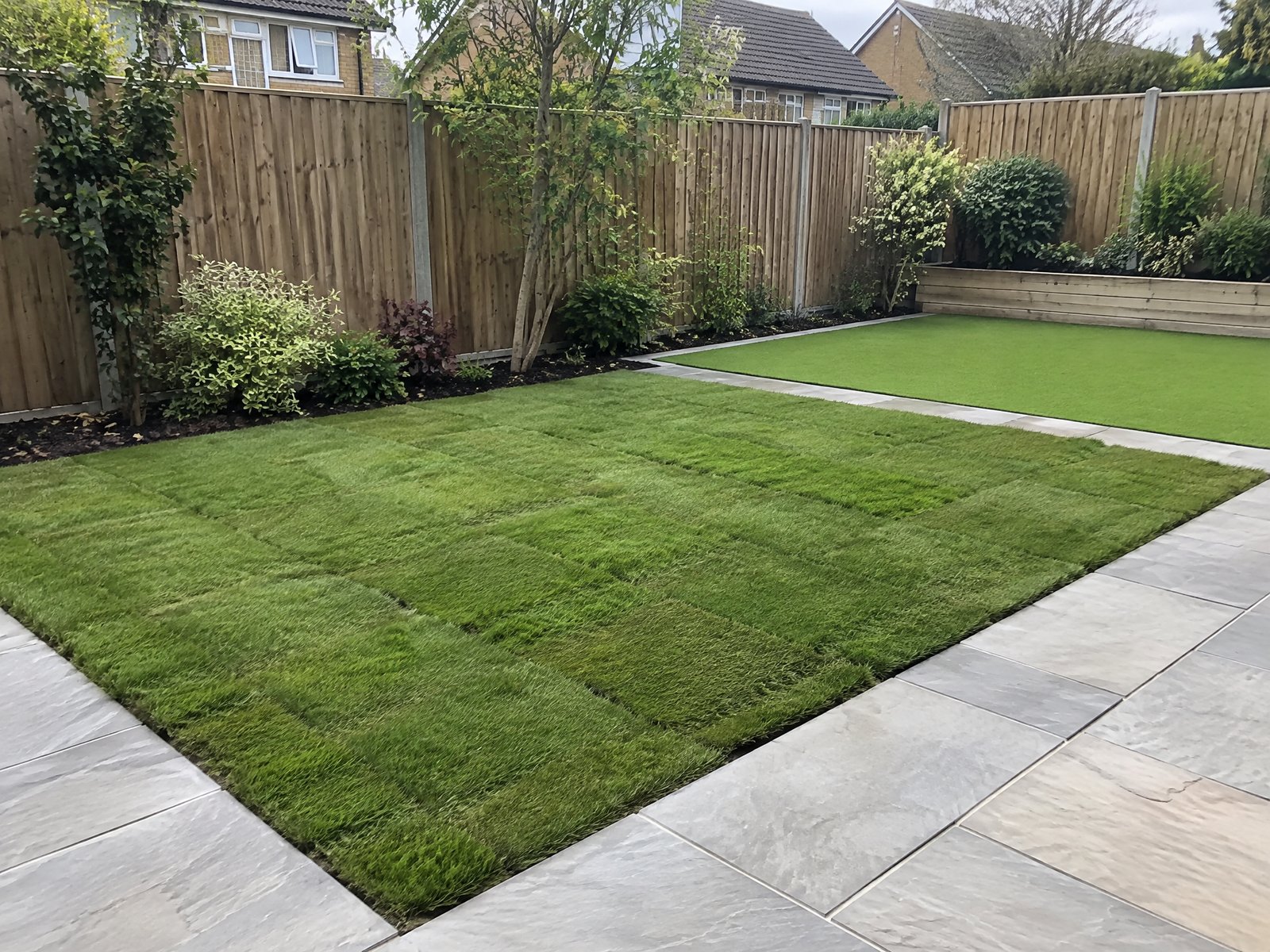Illustrative image: newly laid turf lawn beside artificial grass, edged with paving